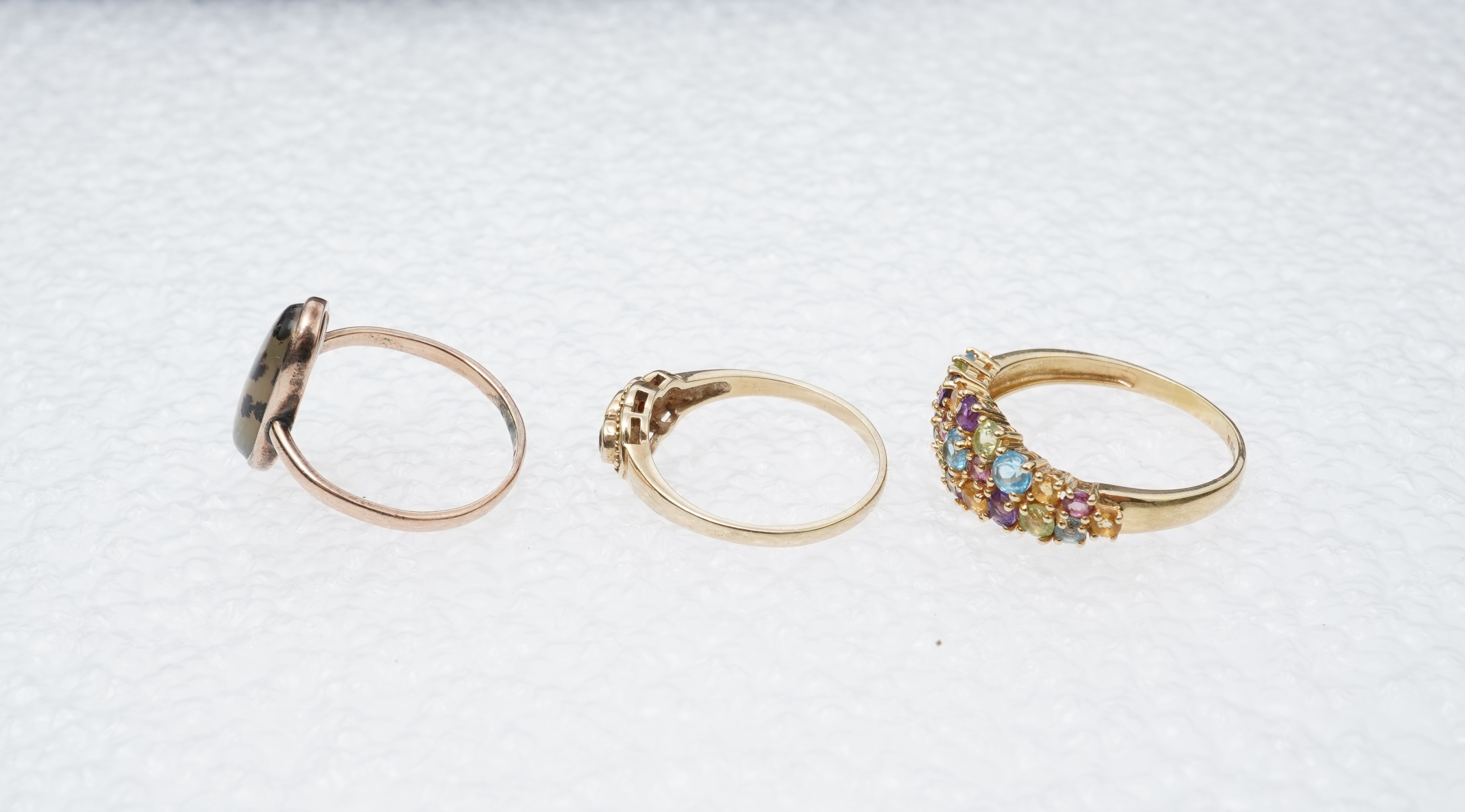 A modern 18ct gold and multi gem set cluster ring, size P, together with two 9ct rings including moss agate and a pair of 9ct gold and seed pearl set cabochon garnet ear studs.